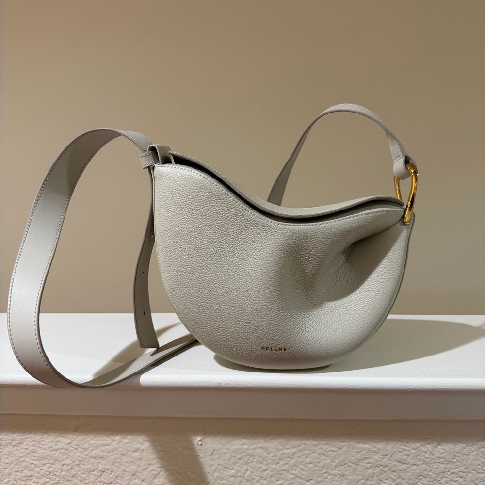Polène crescent crossbody bag in light gray with gold hardware